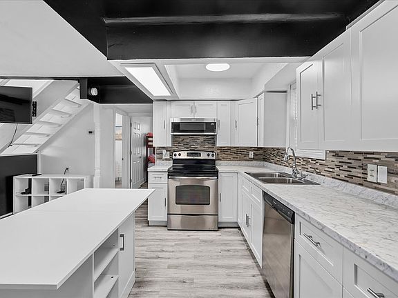 Open kitchen with brand new stainless steel appliances
