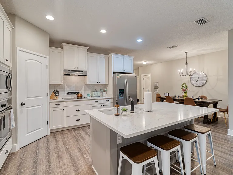 Crisp white cabinetry wraps around the entire space, offering an exceptionally clean look and plenty of room to store your group's favorite snacks