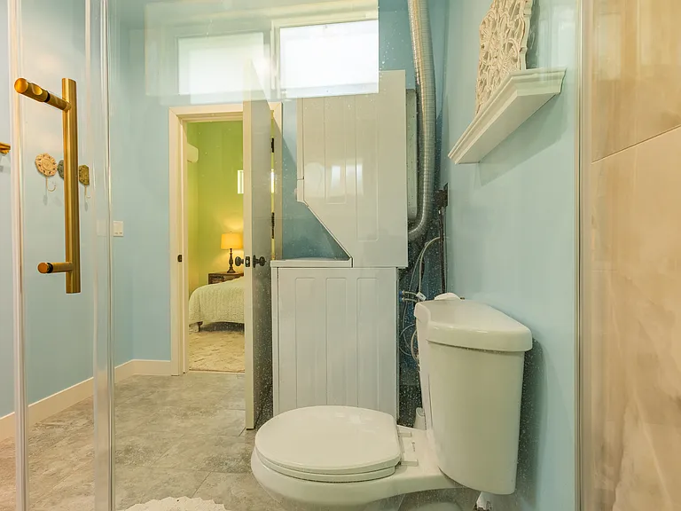 Glacier Bay toilet. Frigidaire Quiet Pack washer and dryer conveniently placed in the bathroom for easy access and cleansing of clothes.