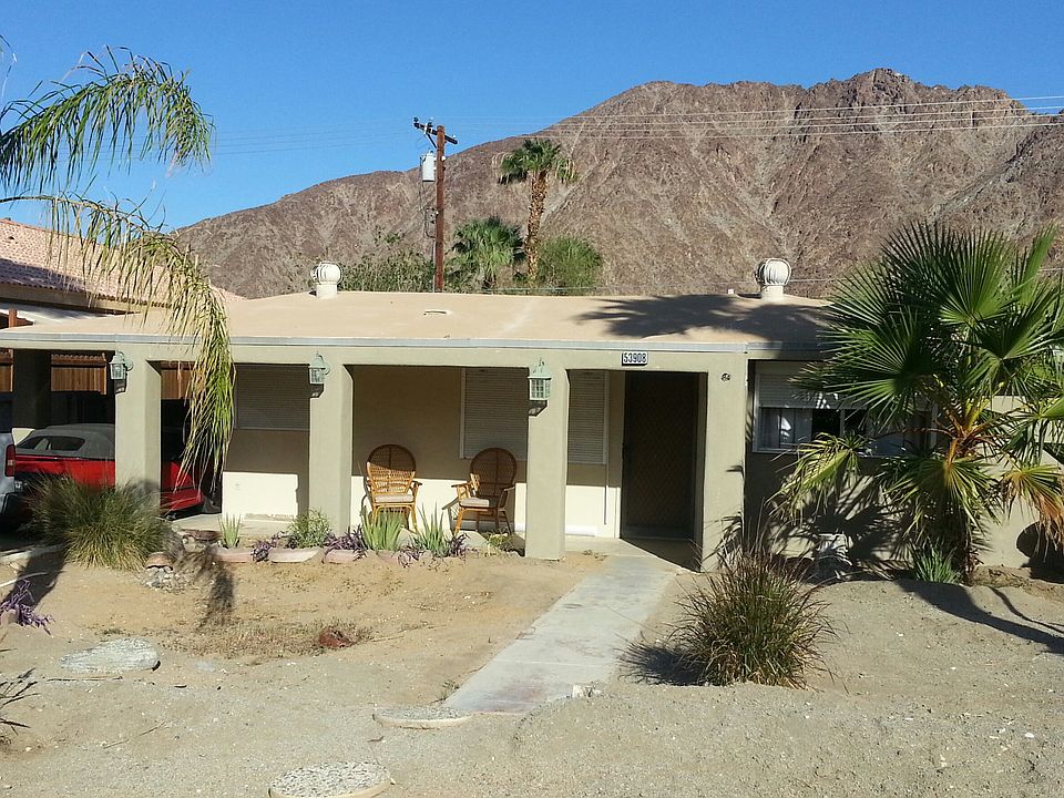 There is a flagstone landing, now before the sidewalk to the house. The palm tree on the right is taller and the one on the left is gone.