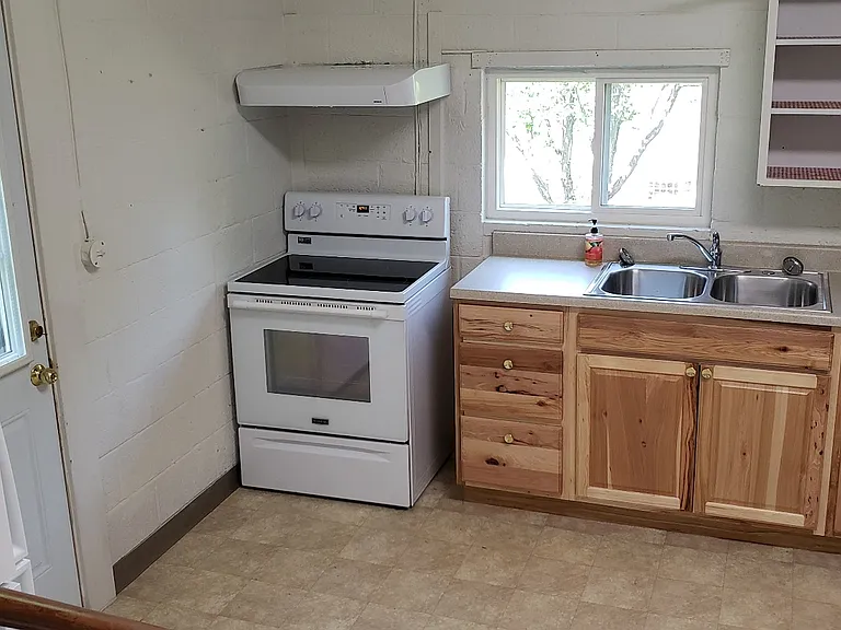 Step down from the living room to the kitchen, a side door gives access to the well-maintained yard
