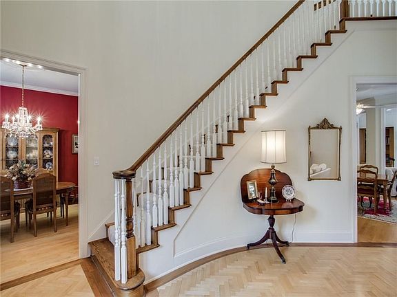 Dramatic curved staircase and gorgeous herringbone maple hardwood floors invite you in to this Bruce Ott custom home.