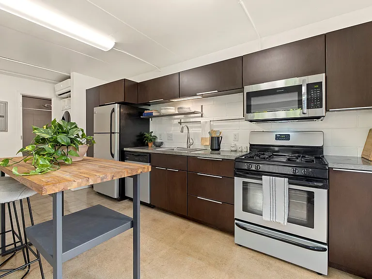 Kitchen with concrete counters, gas range, microwave, and full size dishwasher and fridge Kitchen with concrete counters, gas range, microwave, and full size dishwasher and fridge