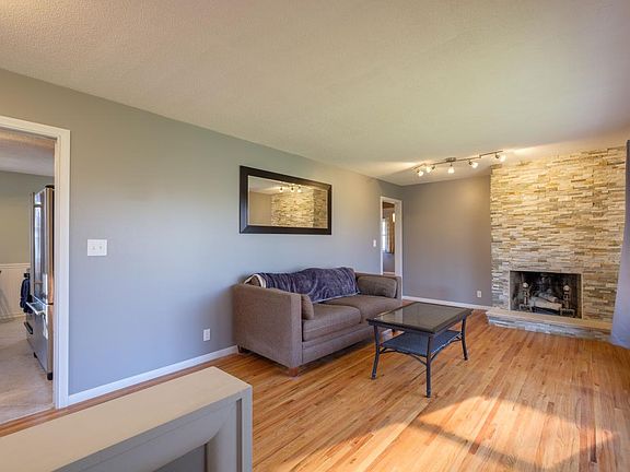 Living room featuring large front window and stone fireplace