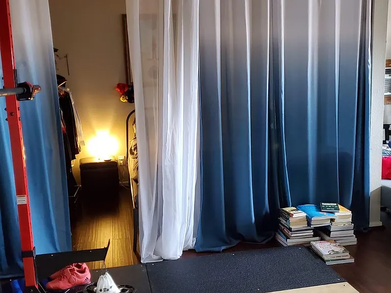 Curtained off bedroom area, curtain rods are staying.