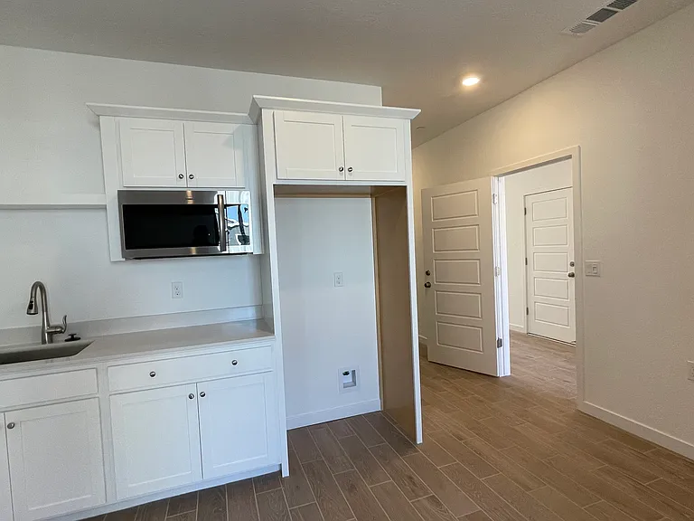 Living Room with Kitchen Sink, Microwave and Refrigerator.