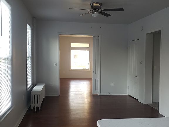 View of from the kitchen to the living room. It shows a dining/seating area. The primary bedroom and the bathroom are to the right.