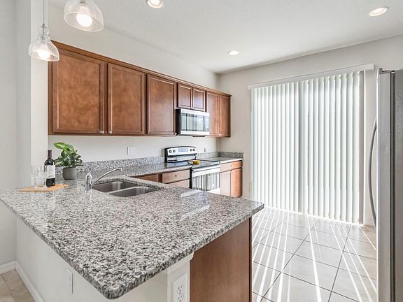 Open kitchen with breakfast bar, granite countertops, and natural light