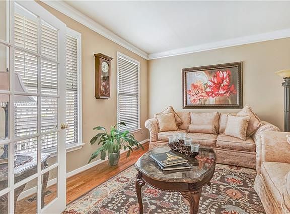 Formal living room with French doors, crown molding, and hardwood floors