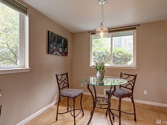 Light filled dining room (adjacent to the kitchen). Just to the right is a free-standing cabinet with glass shelving on top as well as another cabinet below.