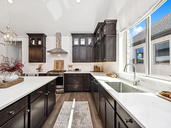 Kitchen with stainless steel appliances and glass upper cabinets