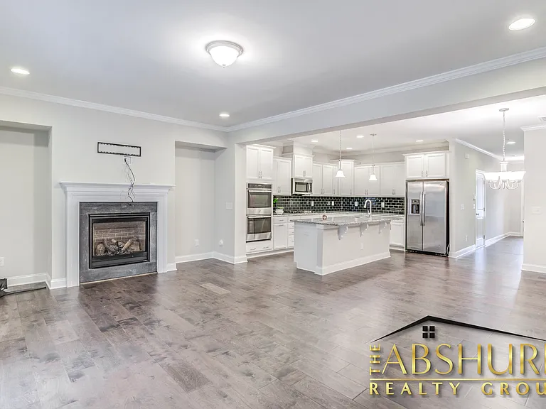 Open concept living room with crown molding, gas fireplace and energy efficient recessed lighting