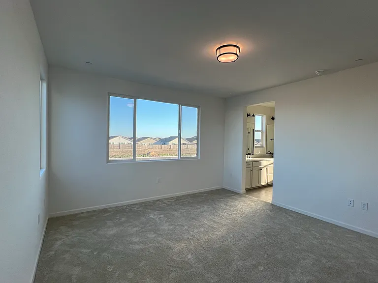 Primary Bedroom: A spacious primary retreat with an ensuite bath and gorgeous natural light _ your private escape at the end of the day.
