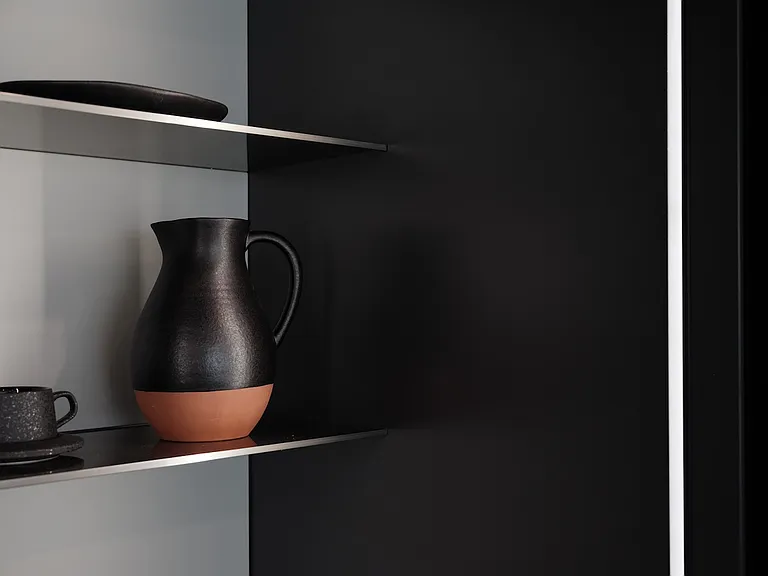 Sculptural Shower with Dramatic Stone Finishes _ This striking shower design features bold veined black stone, precision-cut paneling, and integrated shelving.