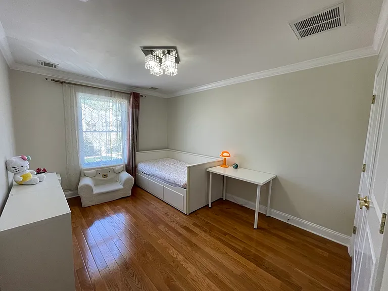 Bright and versatile third bedroom with hardwood floors and natural light