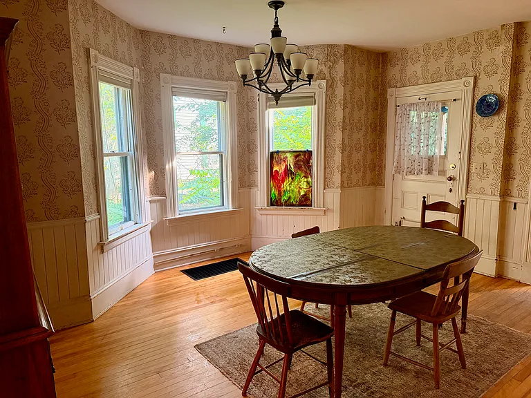 Dining room, with side door to fenced front yard. Kitchen at left, living room, bathroom, & downstairs side bedroom to right.