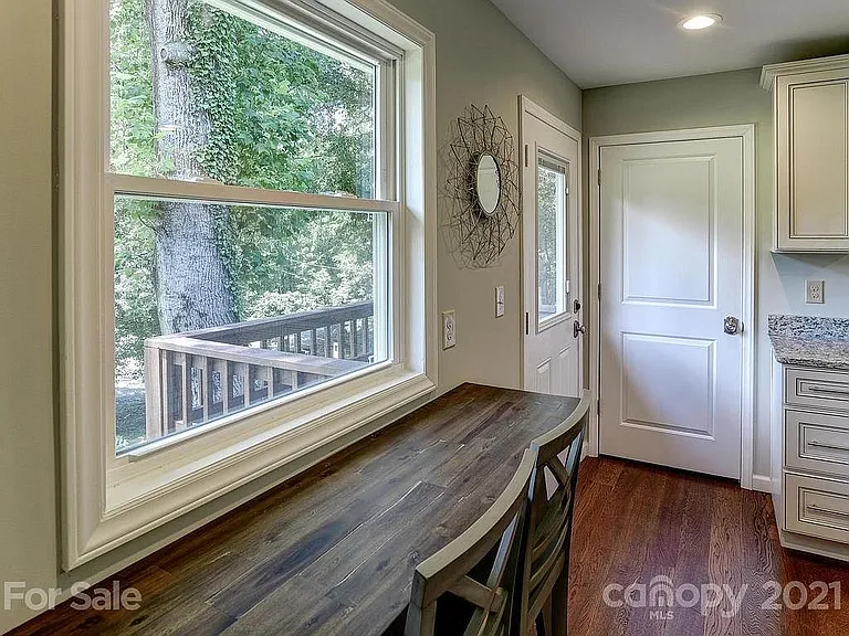 Patio outside kitchen with steps down to ample deck.