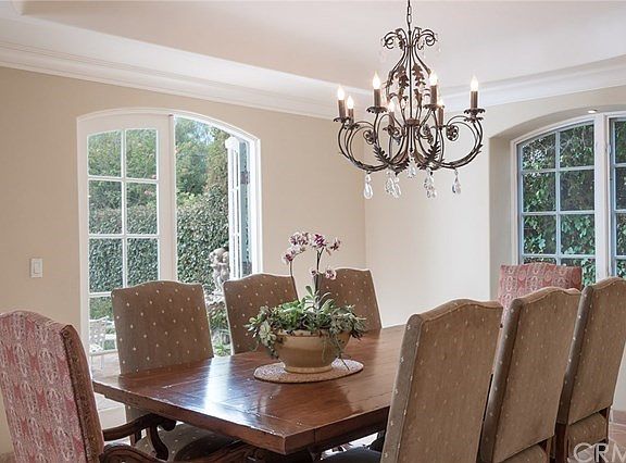 Magnificent Dining Room with Coffered Ceiling and Arch Detailed Windows and French Doors
