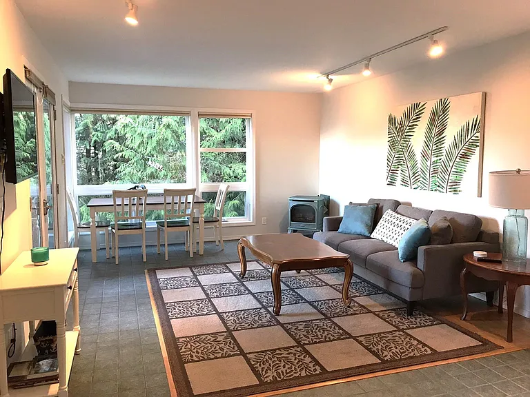 Sunny living room and dining area, with fireplace in the corner.