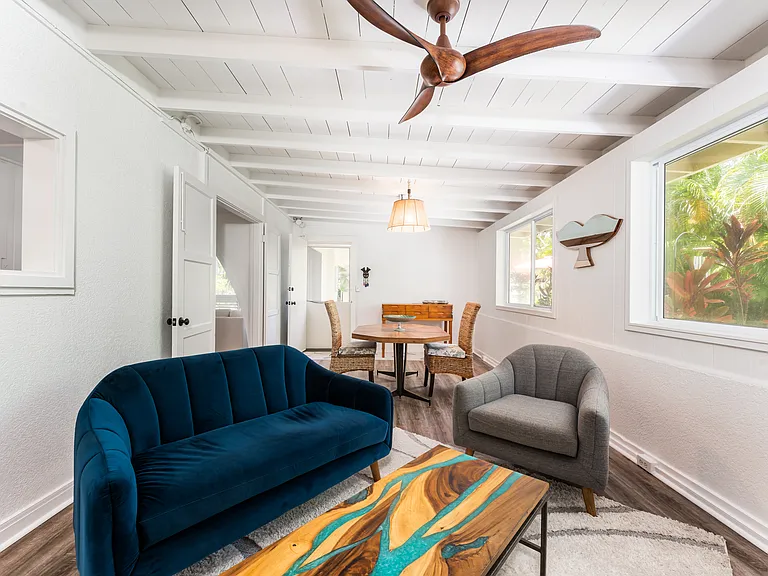Bright entry room in the main home featuring open beam ceilings, luxury vinyl flooring, and abundant natural light.