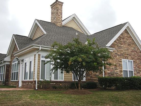 Full brick and stone veneer with mature landscaping on a corner lot