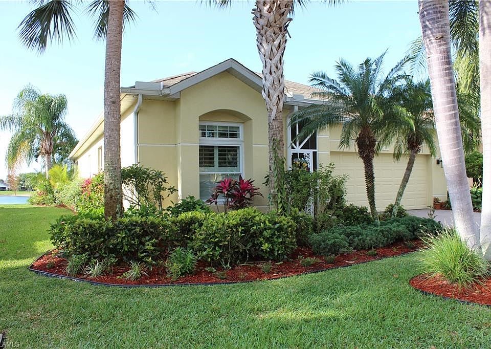 Left front of home with view of lush gardens and lake view.