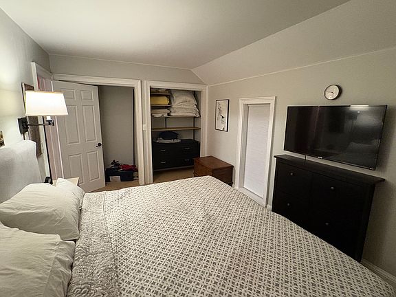 Bedroom with king sized bed and 2 double closets for hanging and dresser for clothing. Shoe storage cabinet under TV.
