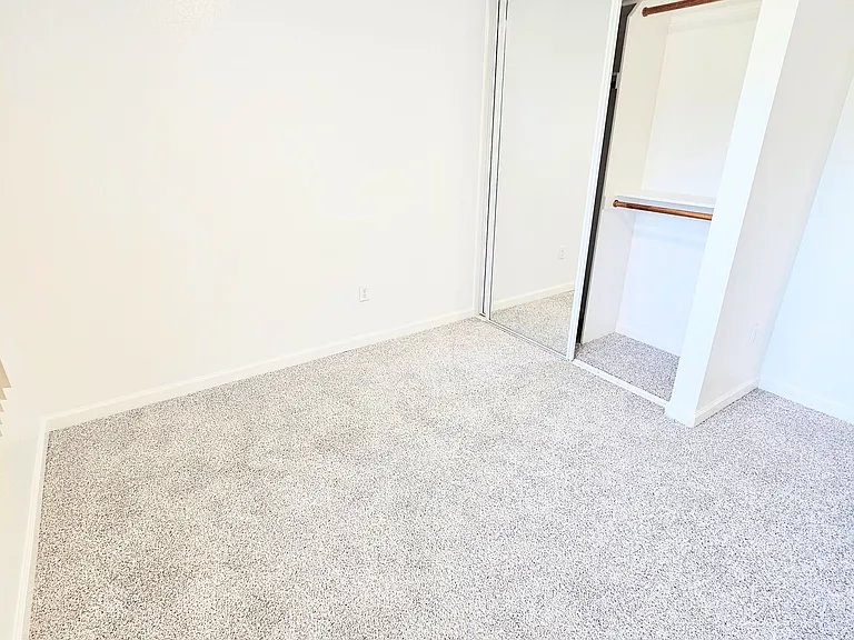 Medium bedroom, mirrored closet with built in shelving and high/low hanging on one side