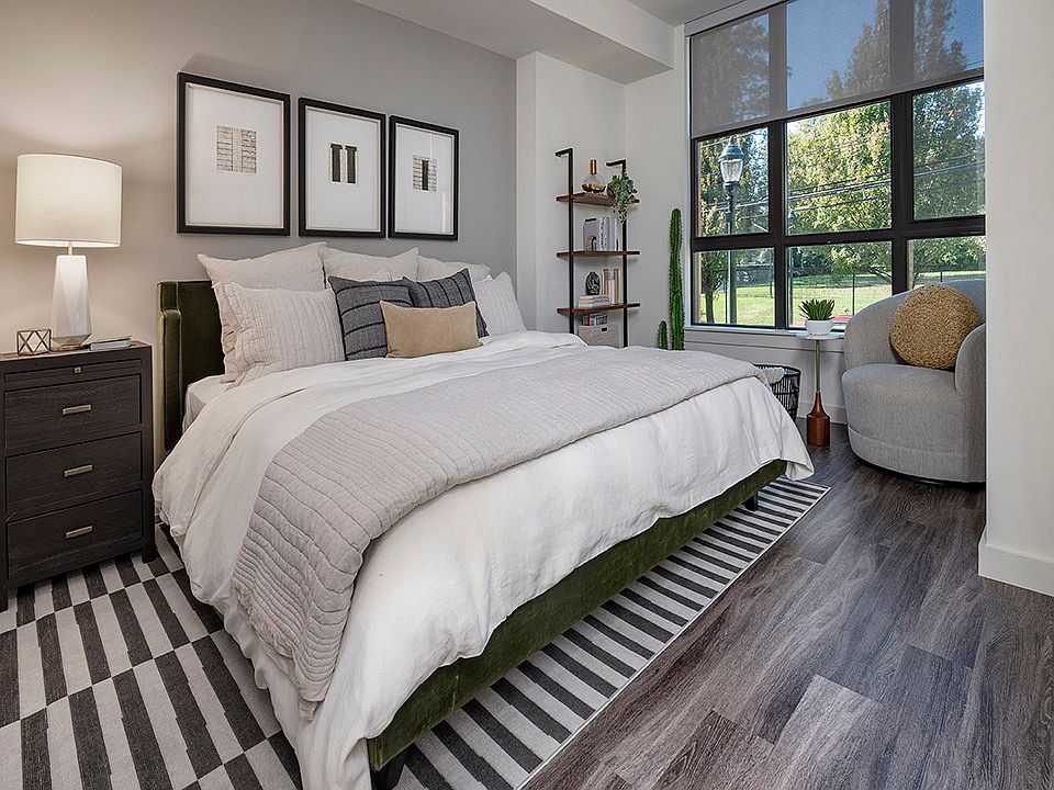 Spacious apartment bedroom with wood-style flooring.
