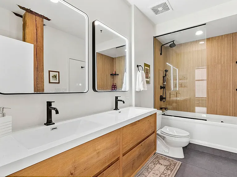 Recently refurbished bathroom with dual sinks and vanity lighting