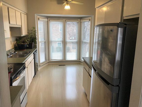 Open kitchen with hardwood floors and stainless steel appliances.