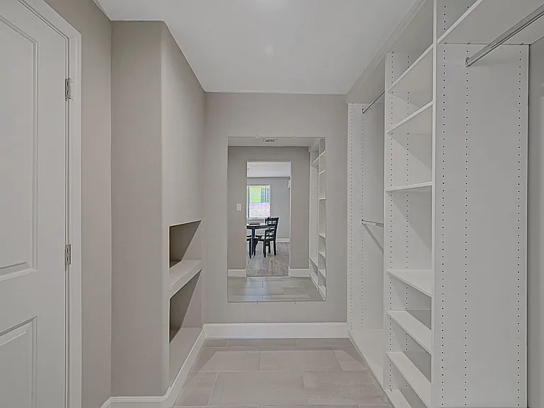 Custom Closet World storage system featuring built-in shelving, hanging space, and full-size mirror