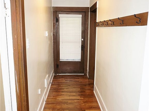 One of the entry doors.  Hardwoods - great millwork in this home.  Full bathroom on left.  Big Family Room on the right.