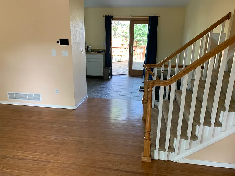 View toward kitchen and through French doors out to deck on west side of house