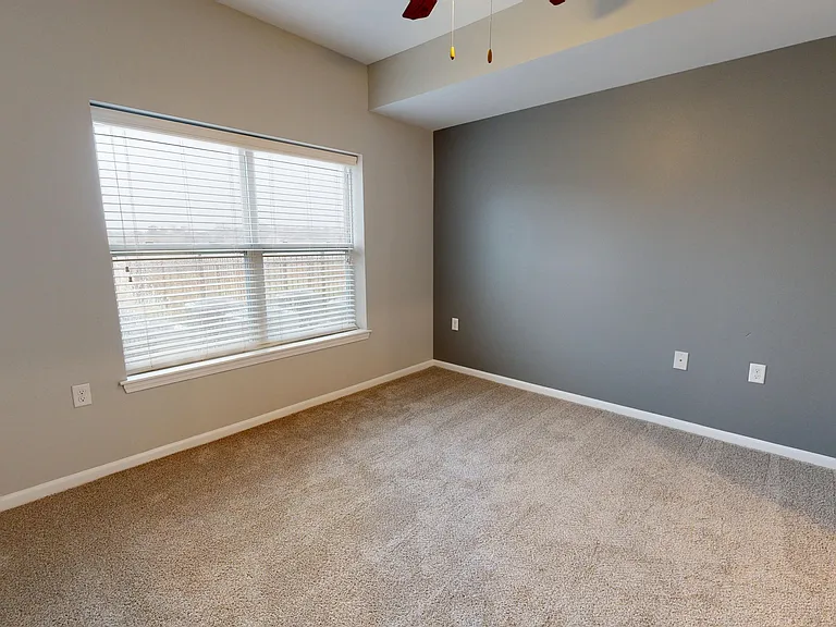 The Redbud's primary bedroom includes a large window, carpet and a ceiling fan. The Redbud's primary bedroom includes a large window, carpet and a ceiling fan.