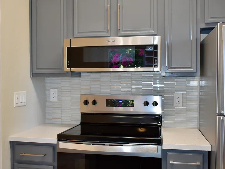 Another view of the Kitchen cooking area and refinished cabinets with new modern hardware.