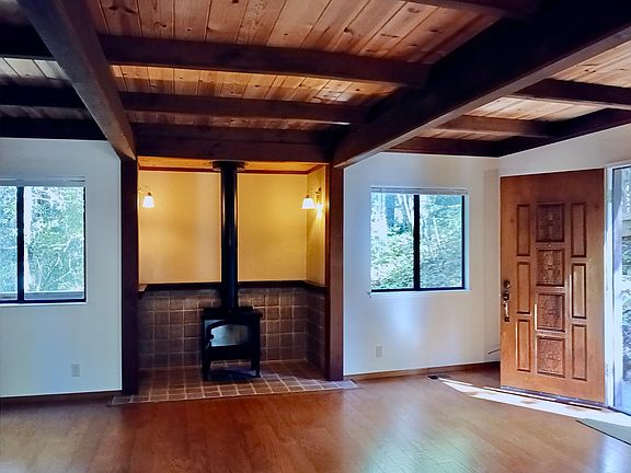 Open plan living area has new hardwood flooring, wood beam ceilings and an inglenook with wood burning stove. Windows have new blinds.