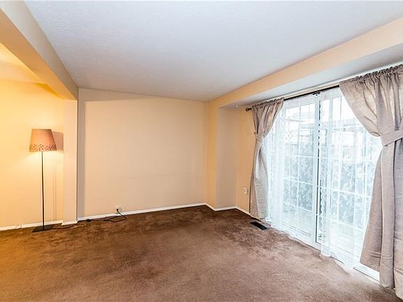 Living room has neutral decor and provides access to the private deck.