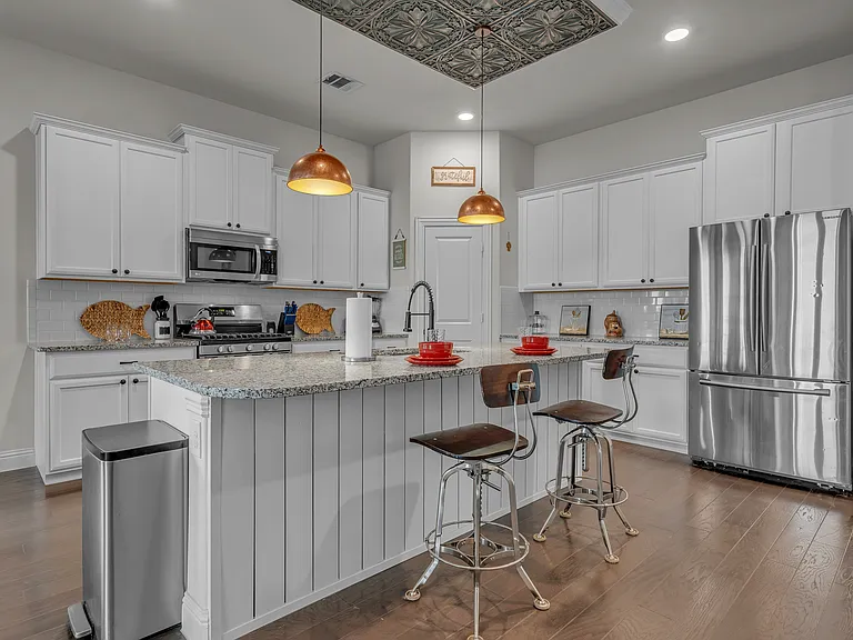 Oversize island with seating in a large, open space kitchen, with walk-in pantry