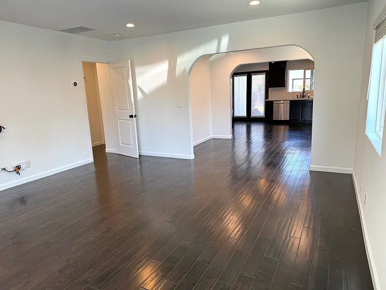 Bright living room filled with natural light, dimmable recessed LED lighting, and pre-wired for TV.