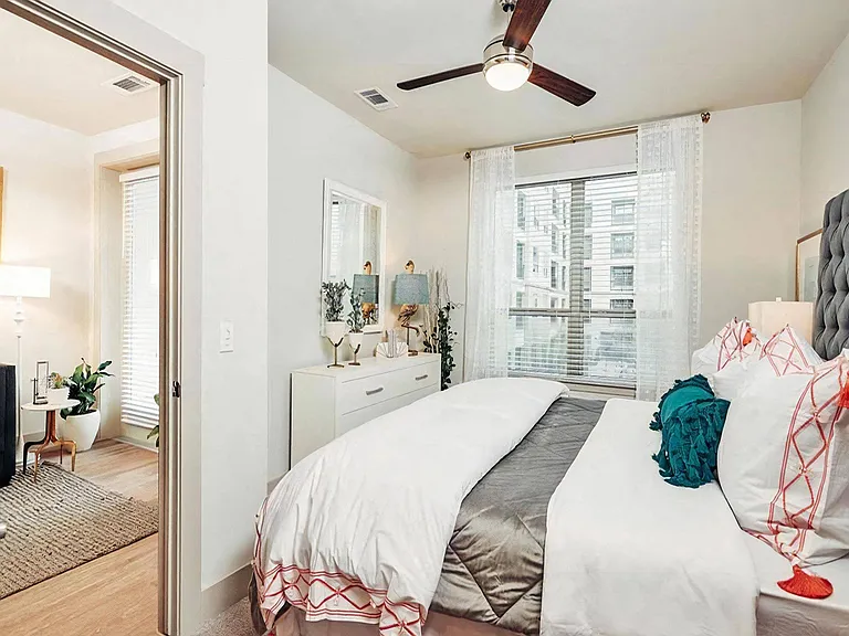 Spacious Bedroom Featuring Ceiling Fan and Natural Light