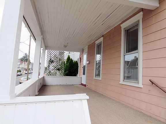 Front porch, covered with outdoor carpet & climbing rose bus