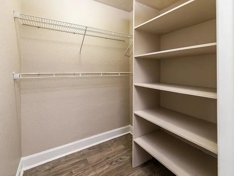 Delight in a large closet space with custom built shelving for optimal wardrobe organization.