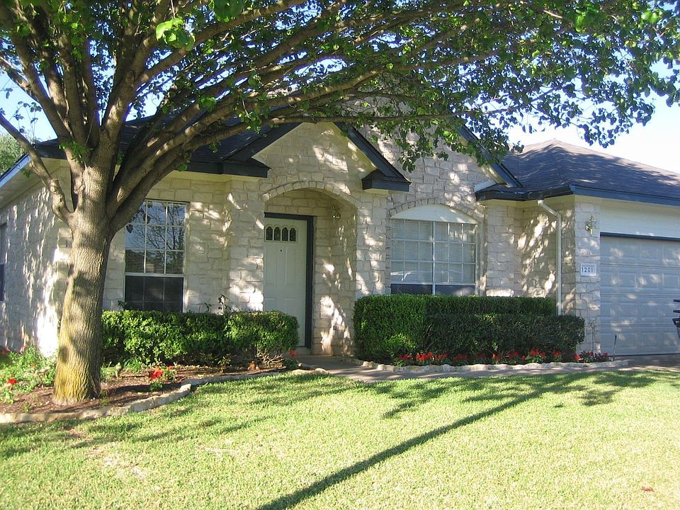 white stone home on treed lot