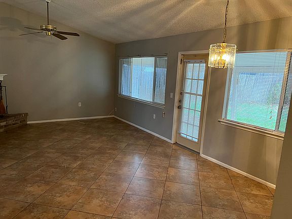 Family room, ceiling fan and lots of windows and light. Door to patio