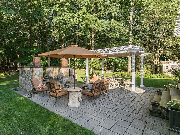 Expansive patio features seating area around pizza oven and fire pit.