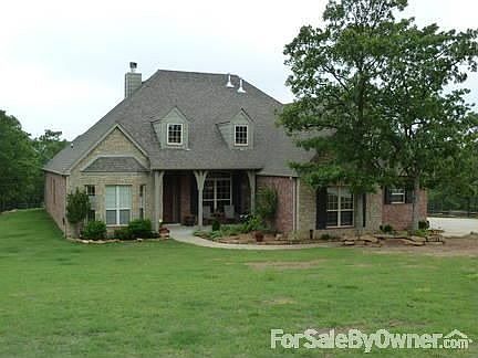 Front : Front entrance is welcoming with flower beds and a covered porch.