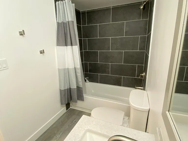 New large shower tile and new tub. Towel hooks and shower curtain included.