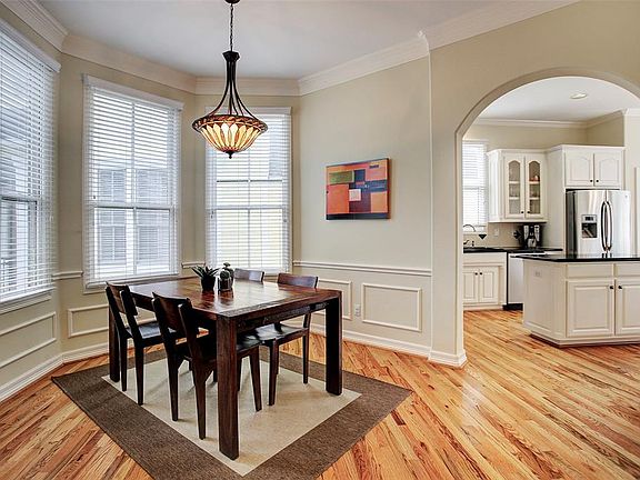 Spacious dining room has large bay windows, decorative chair railing and a beautiful stained-glass chandelier.