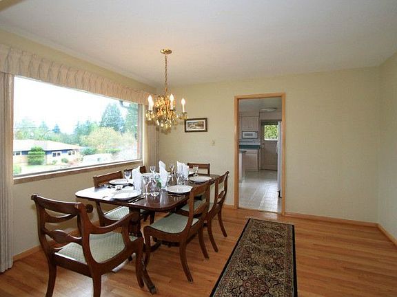 Formal dining room with a big picture window. Plenty of room for additional seating or buffet.